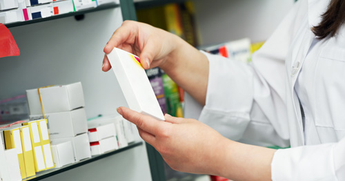 Female pharmacist holding a box of medication